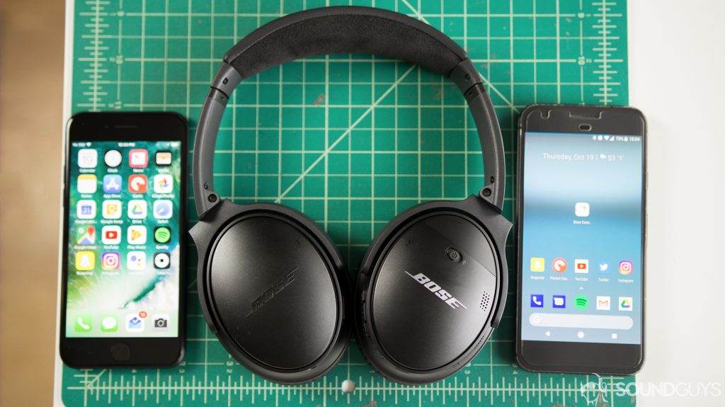 An aerial picture of the Bose QuietComfort 35 II on a gridded surface next to two smartphones.