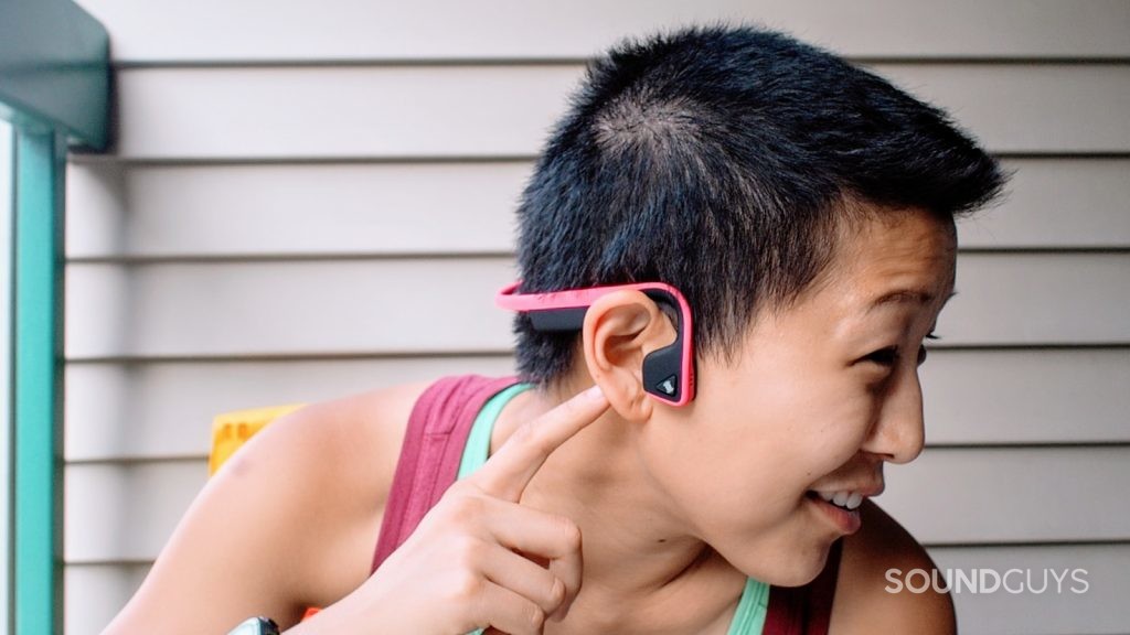 A picture of a woman wearing the Aftershokz Trekz Titaniuum which many use as running earbuds.