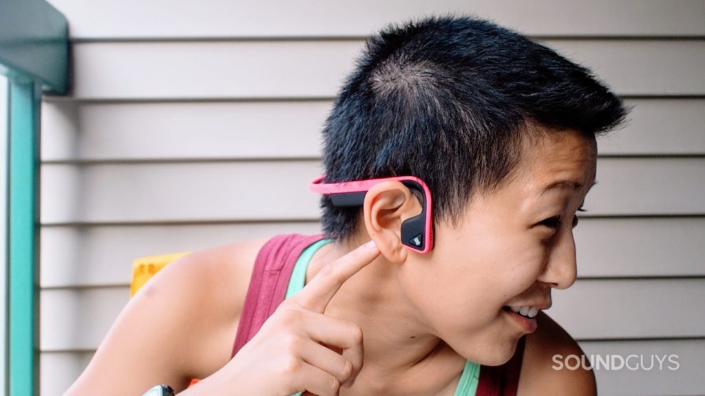 A woman wears the Aftershokz Trekz Titanium bone conduction headphones.