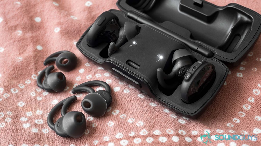 A picture of the Bose SoundSport Free true wireless workout earbuds in black against a pink background.