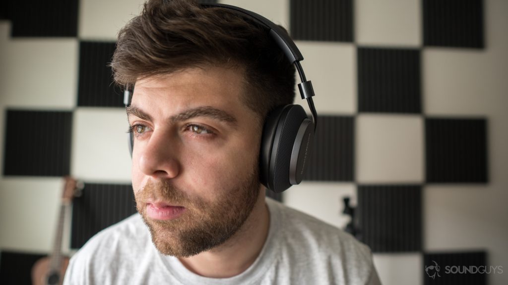 A photo of a man hearing wireless Bluetooth headphones, the Bowers & Wilkins PX.