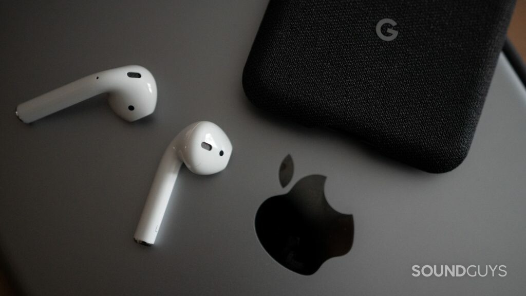 Pictured are the Airpods on top of an iPad and next to the Google Pixel 3.
