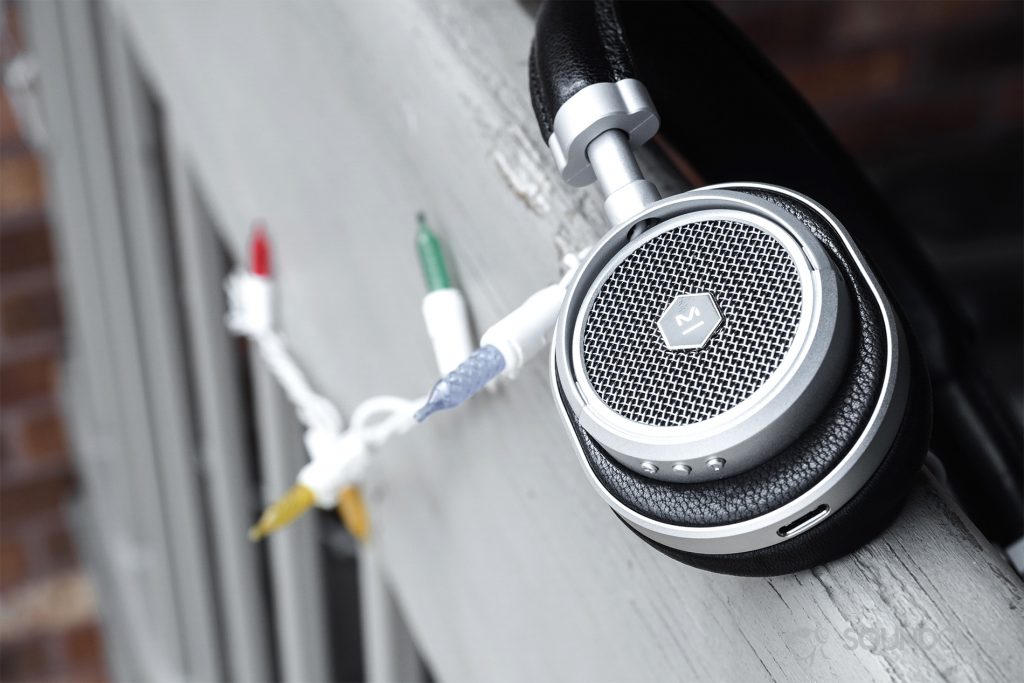 Master & Dynamic MW50 Wireless review: The headphones resting on a balcony railing with lights in the background.