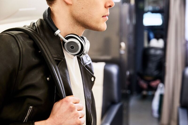 The Master & Dynamic MW50+ Wireless worn around a man's neck. The headphones are in black.