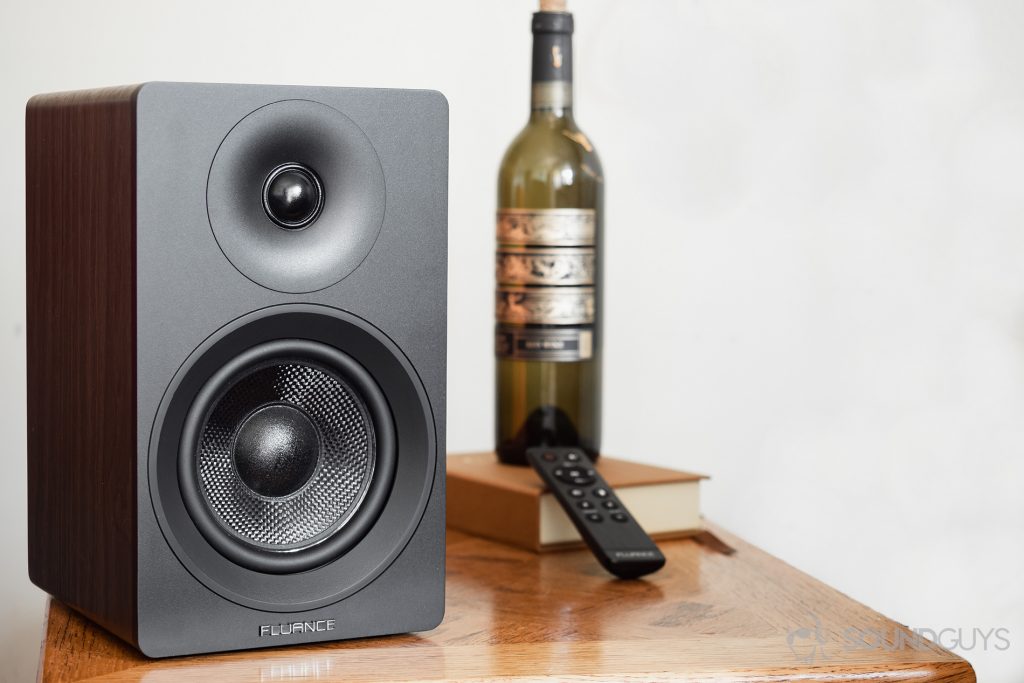 3D sound - Fluance Ai40 review: The passive speaker on a table with a wine bottle in the background and the remote.