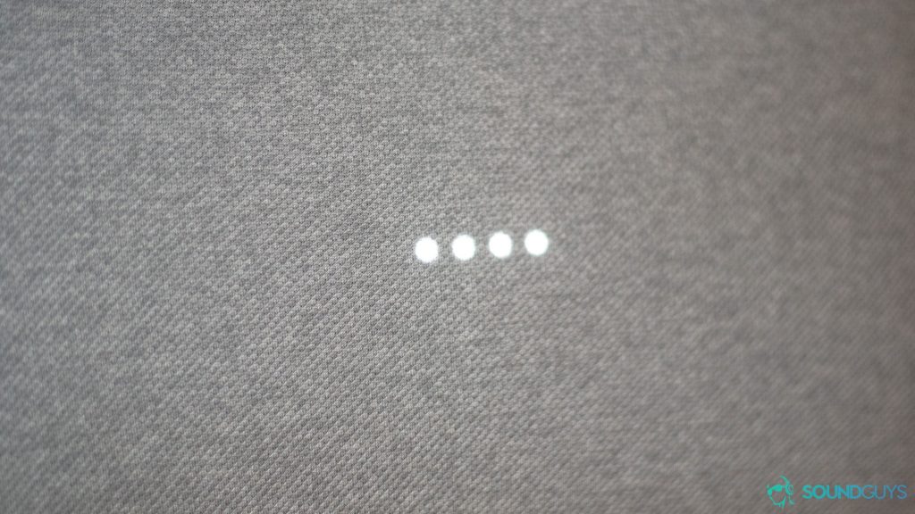 Close up of the fabric of the speaker with the four LED lights lit up to show that the speaker has detected the hotword. 