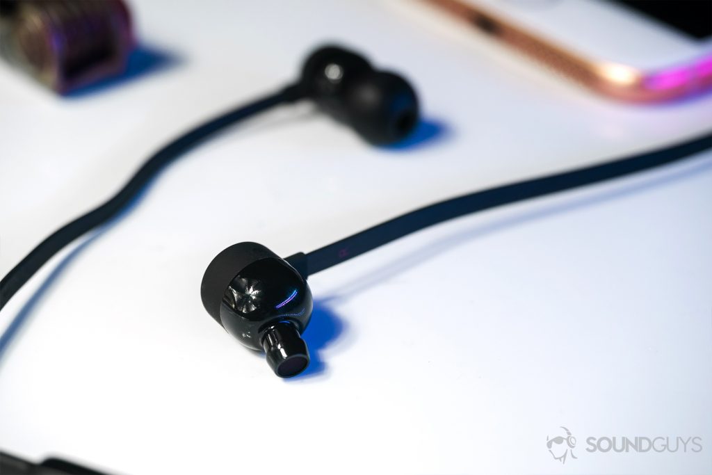 The angled nozzles of the BeatsX earbuds on a white surface.