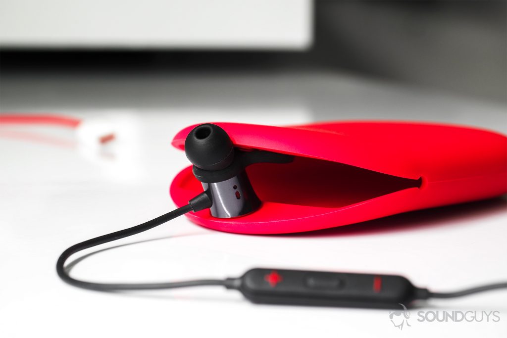 A straight-on image of the OnePlus Bullets Wireless earbuds with one of them holding the opening of the carrying case open.