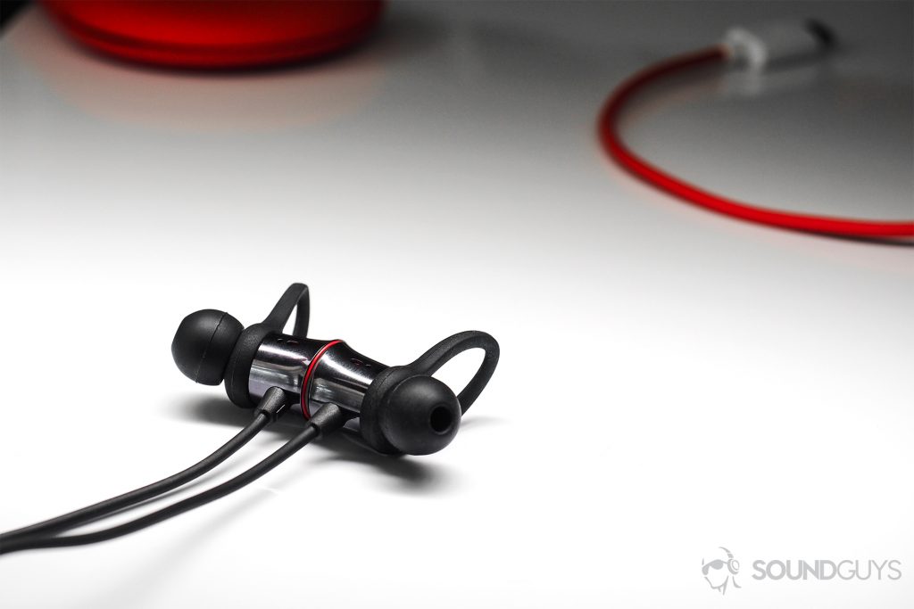 An angled image of the OnePlus Bullets Wireless earbuds with part of the cable and case in the background.