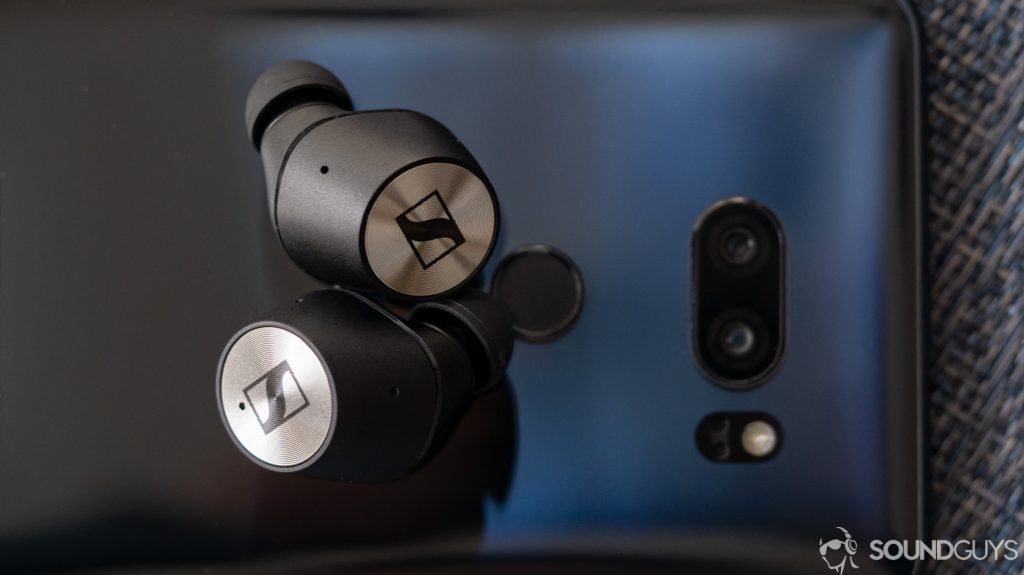 A photo of the Sennheiser Momentum True Wireless earbuds resting atop a phone.