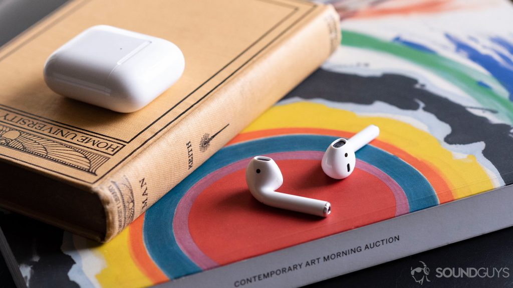 Apple new AirPods 2 on an arts magazine with the case above it, shut.