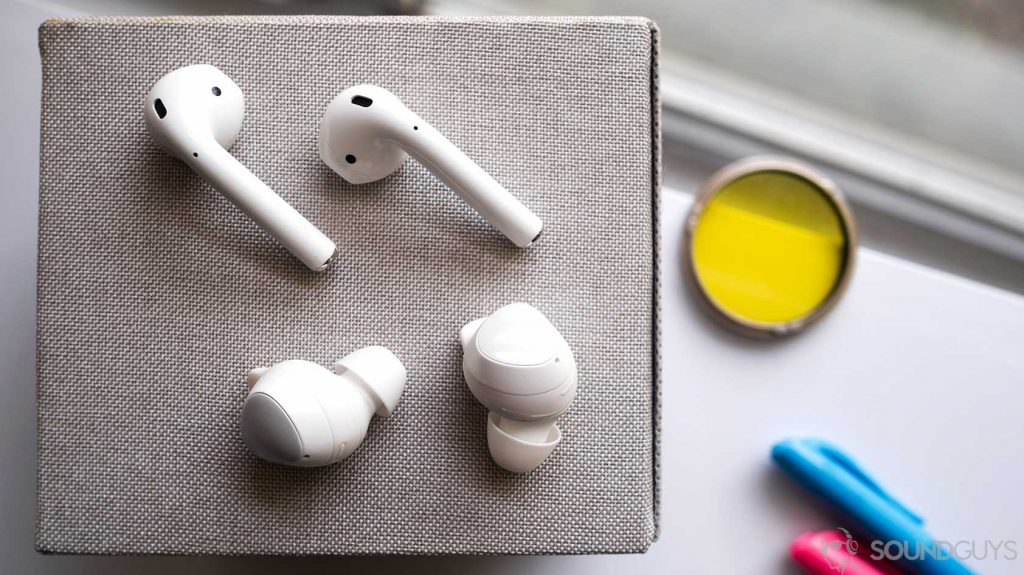 An aerial photo of the Samsung Galaxy Buds v Apple AirPods in rows on a grey box.