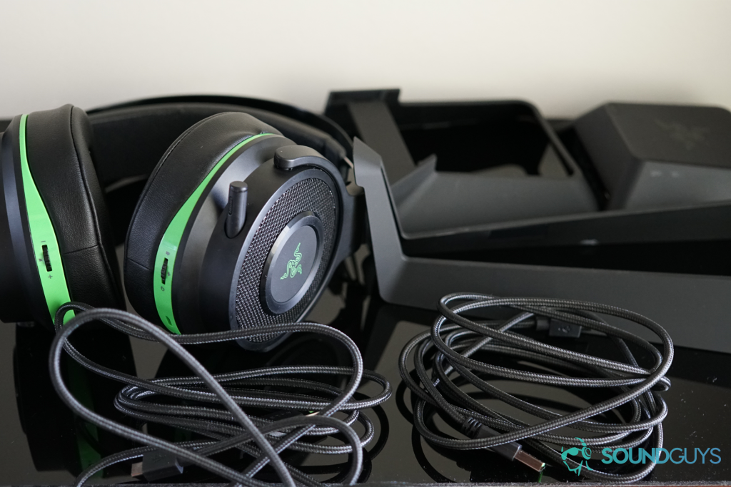 The Razer Thresher lays on a black reflective surface with its various accessories.