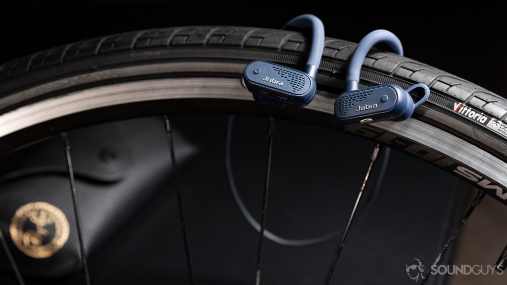 A photo of the Jabra Elite Active 45e earbuds hanging from a road bike tire.
