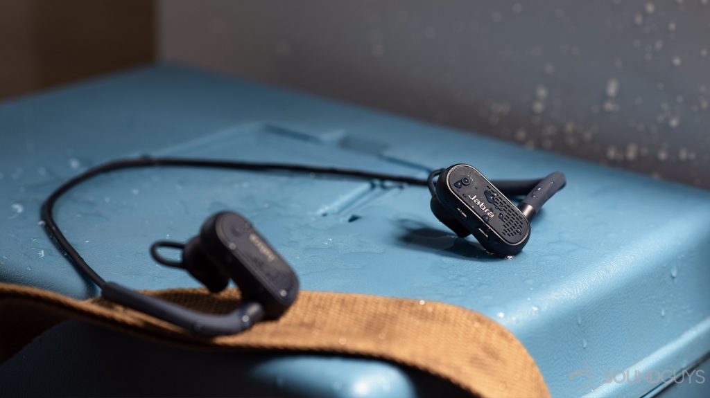 A photo of the Jabra Elite Active 45e earbuds on a blue surface splashed with water.