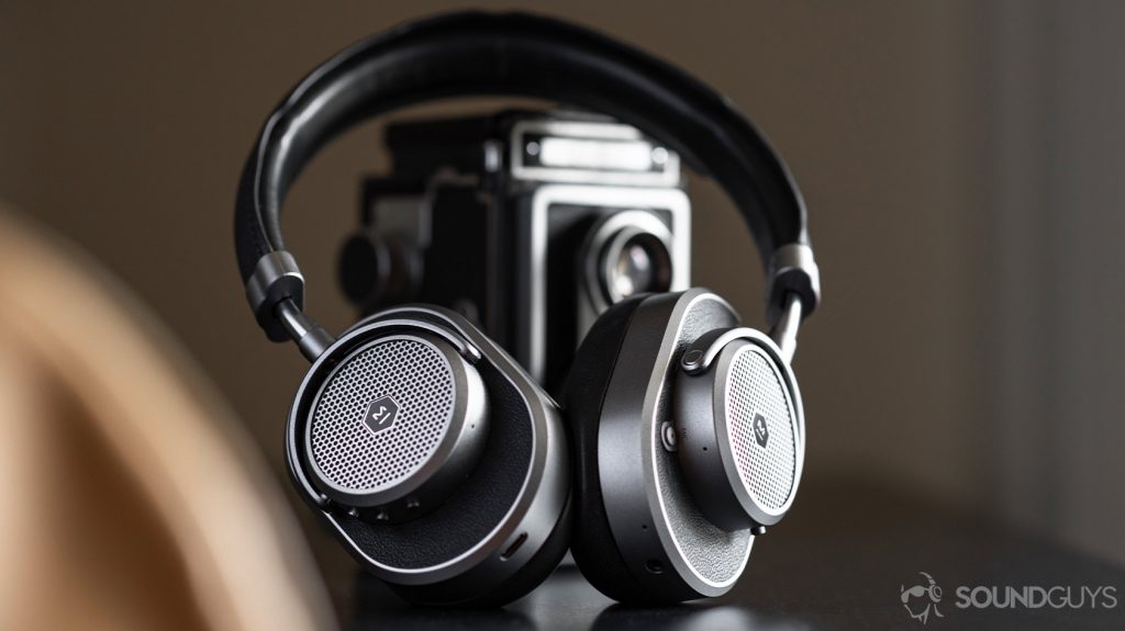 Master & Dynamic MW65: Headphones angled and leaning against a vintage camera.