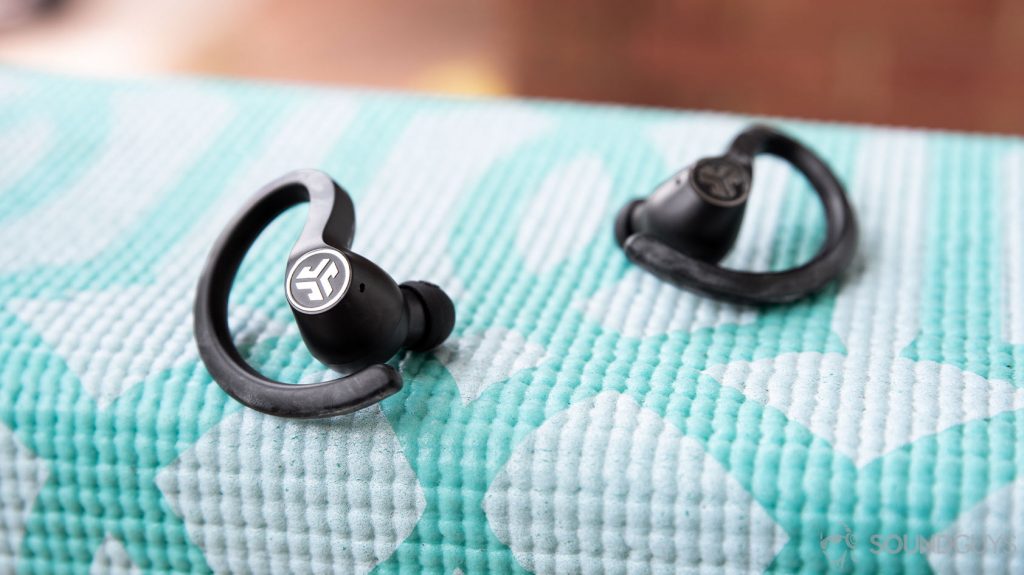 The earbuds resting on a teal yoga mat.