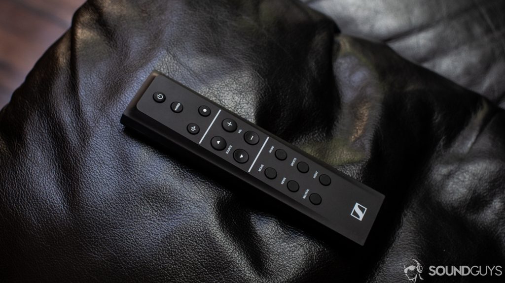 A photo of the Sennheiser Ambeo Soundbar's remote on a leather couch arm.