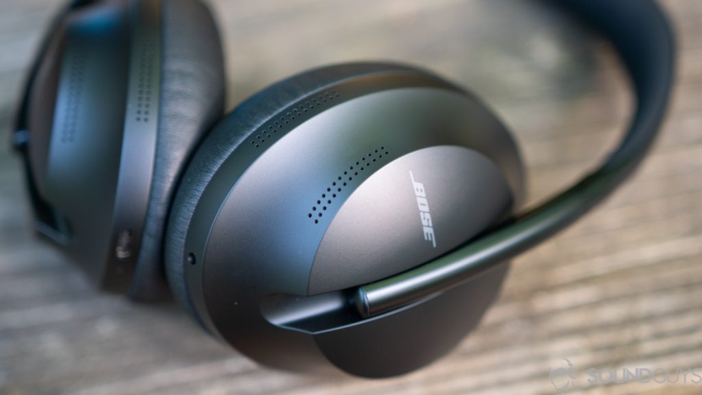 The Bose Noise Cancelling Headphones 700 on a wooden surface with the Bose logo in focus.