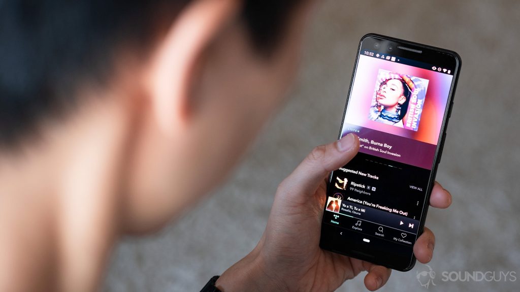 A woman holding a Google Pixel 3 with the Tidal HiFi app, which supports FLAC, pulled up.