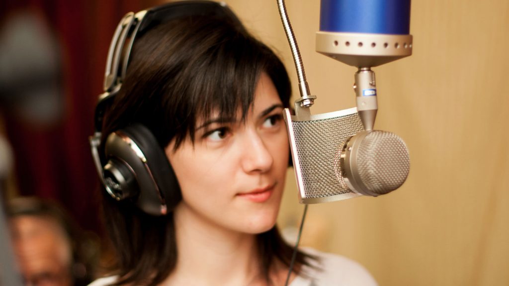 A woman using the Blue Bottle tube microphone in a studio - microphone types explained.