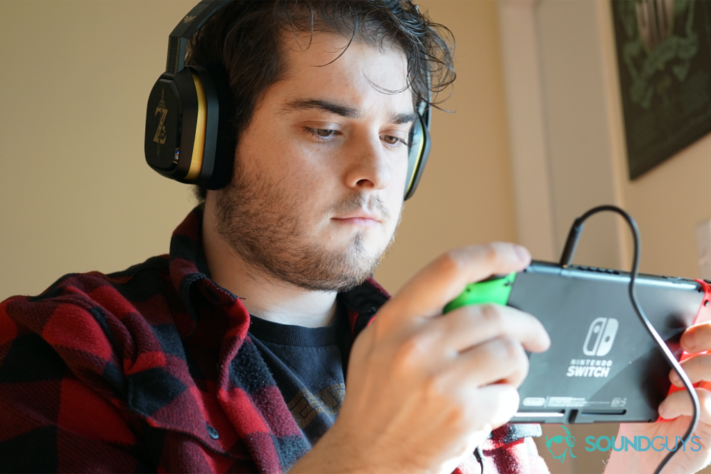 A man plays a Nintendo Switch while using the Legend of Zelda Breath of The Wild Astro A10 gaming headset.