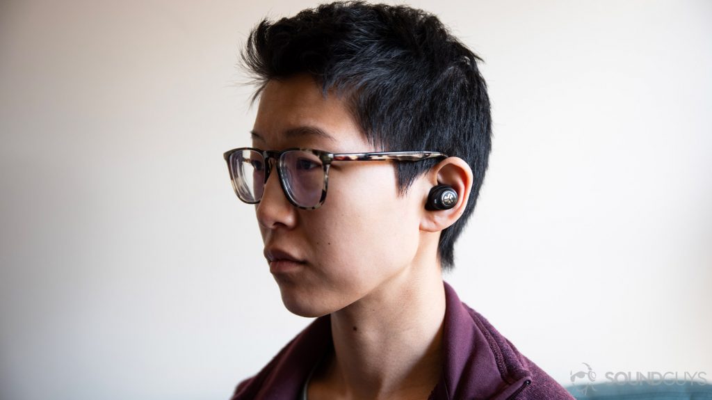 A picture of the JLab JBuds Air Icon cheap earbuds worn by a woman looking to the left of the frame.