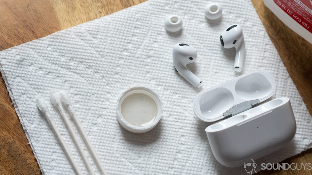 A photo of the AirPods Pro with Q-tips, alcohol, and the bottle cap placed onto paper towels.