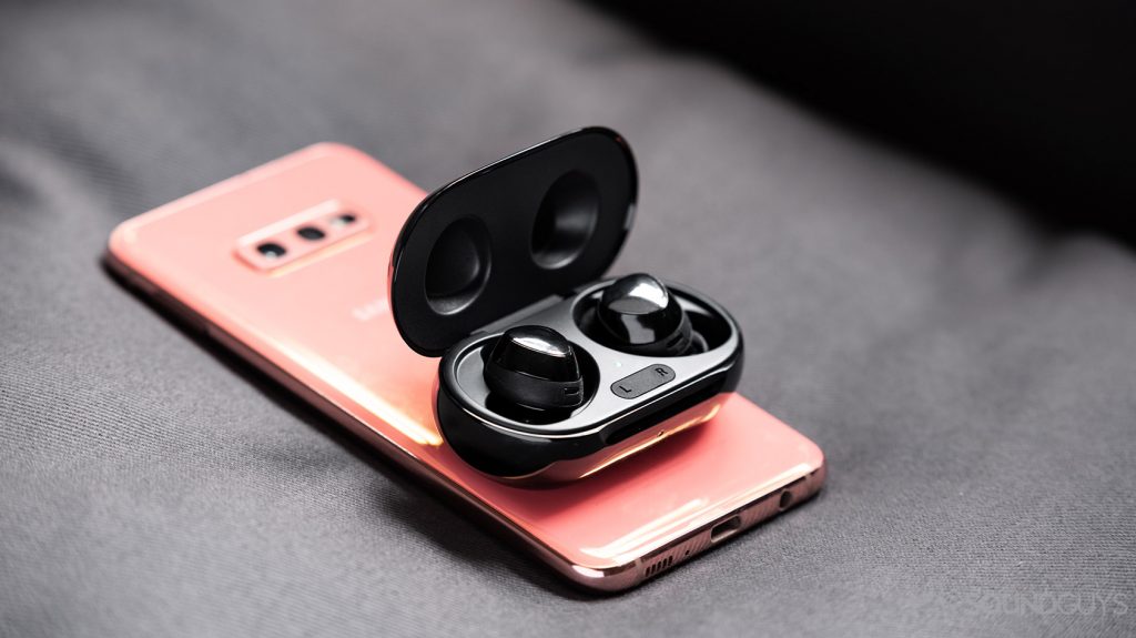 A picture of the Samsung Galaxy Buds Plus true wireless earbuds on top of a Samsung Galaxy S10e smartphone in flamingo pink.
