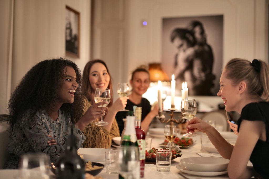 A group of women gather at an indoor dinner party.