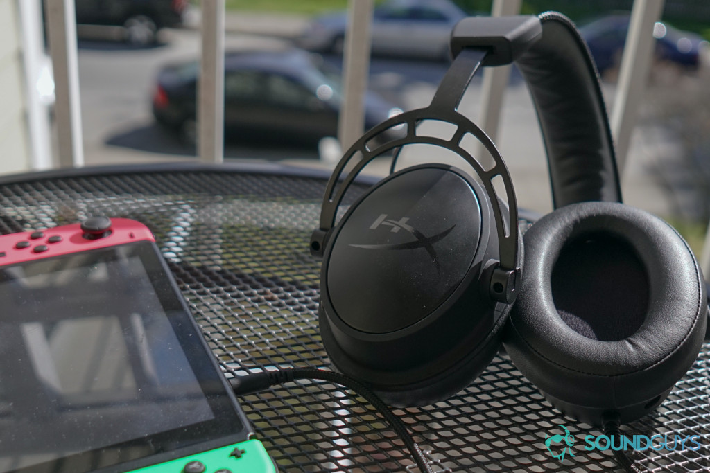 The HyperX Cloud Alpha S sits on a table outside next to an undocked Nintendo Switch.