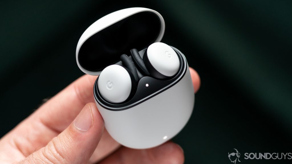 A picture of a man holding open the Google Pixel Buds (2020) charghing case showing the earbuds inside with both LED lights white.