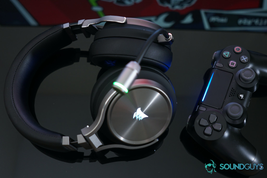 The Corsair Virtuoso Wireless SE over-ear gaming headset next to a PlayStation 4 controller against a black background.