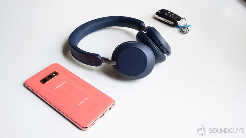 The Jabra Elite 45h on-ear Bluetooth headphones next to a Samsung Galaxy S10e smartphone and wireless car keys on a white table.
