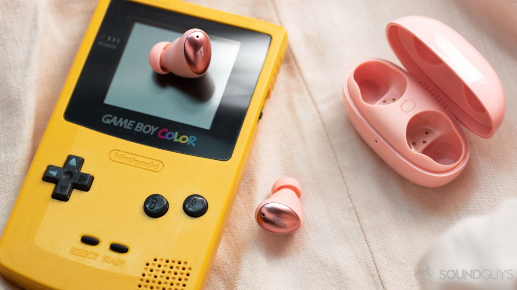 The 1MORE ColorBuds true wireless earbuds on top of a GameBoy, and the charging case is open to the left of the frame.