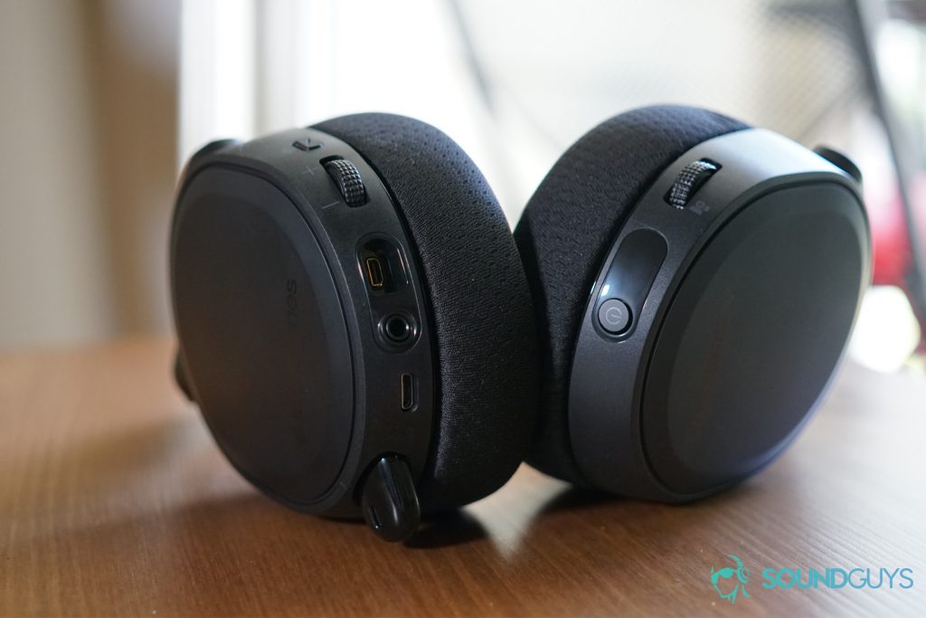 The SteelSeries Arctis 7 Wireless gaming headset lays on a wooden table with its ports in full view