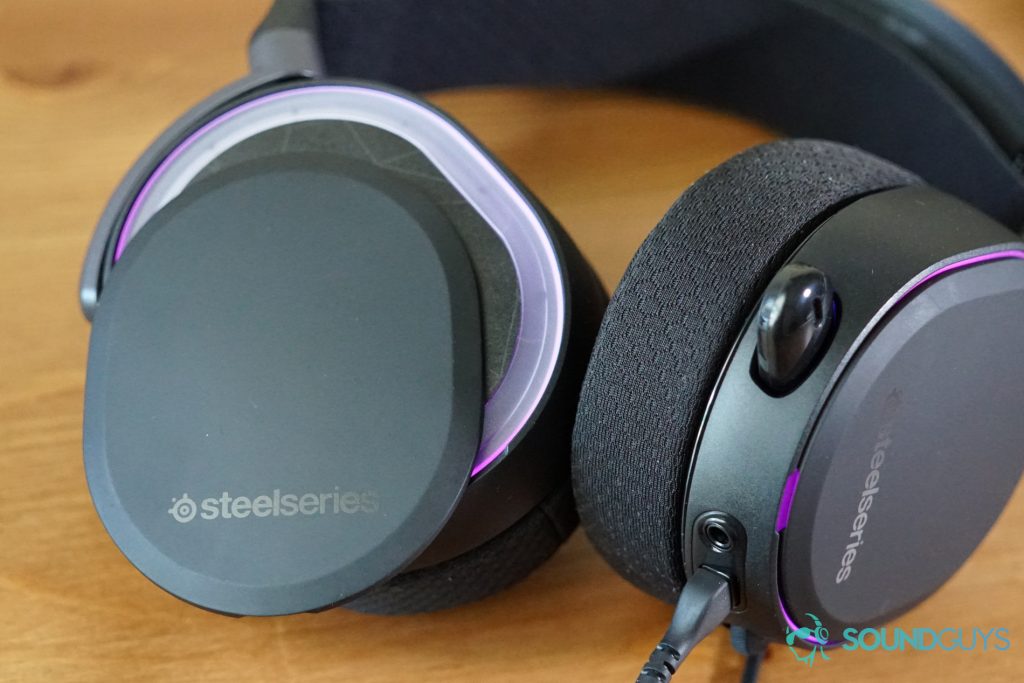 The SteelSeries Arctis Pro lays on a wooden table with its magnetic side plates detached.