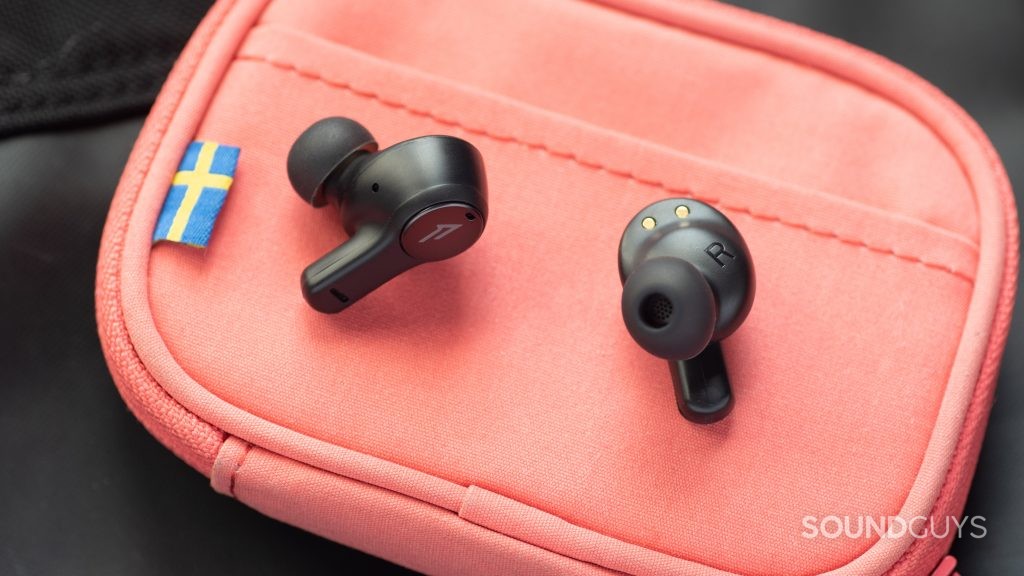 The 1MORE PistonBuds cheap true wireless earbuds on top of a pink wallet.