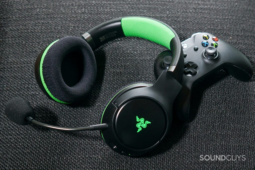 The Razer Kaira Pro leans on an Xbox One controller on a fabric surface.