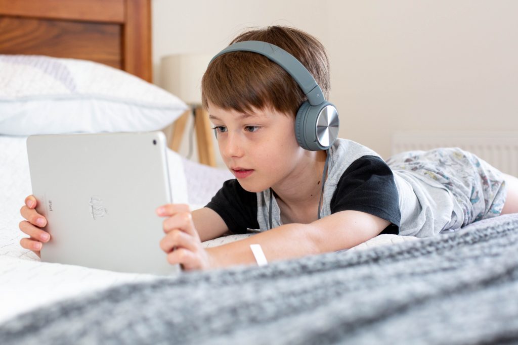 Junge mit Kopfhörern auf einem Tablet