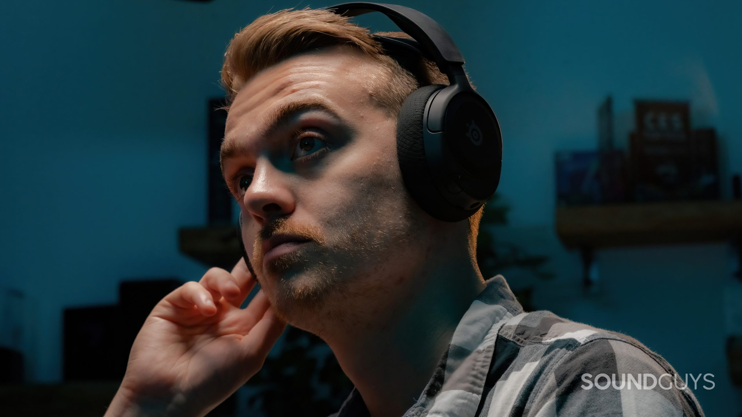 The SteelSeries Arctis Nova 1 being worn by a user with their hand to one of the earcups.