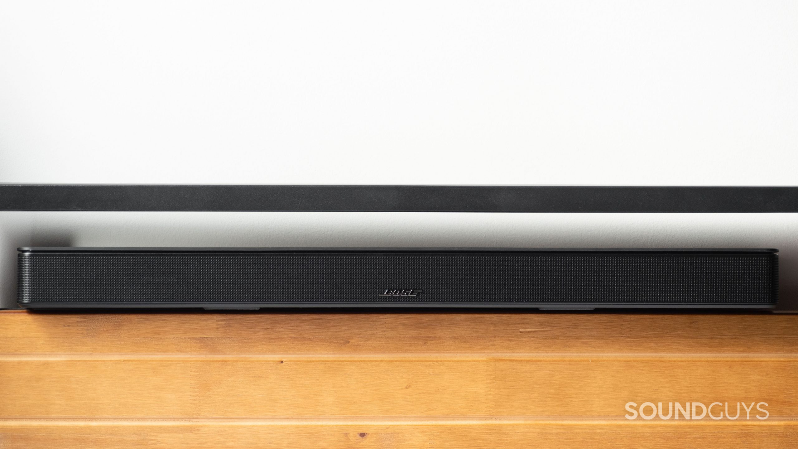 Bose Smart Soundbar 600 מונח על משטח עץ.