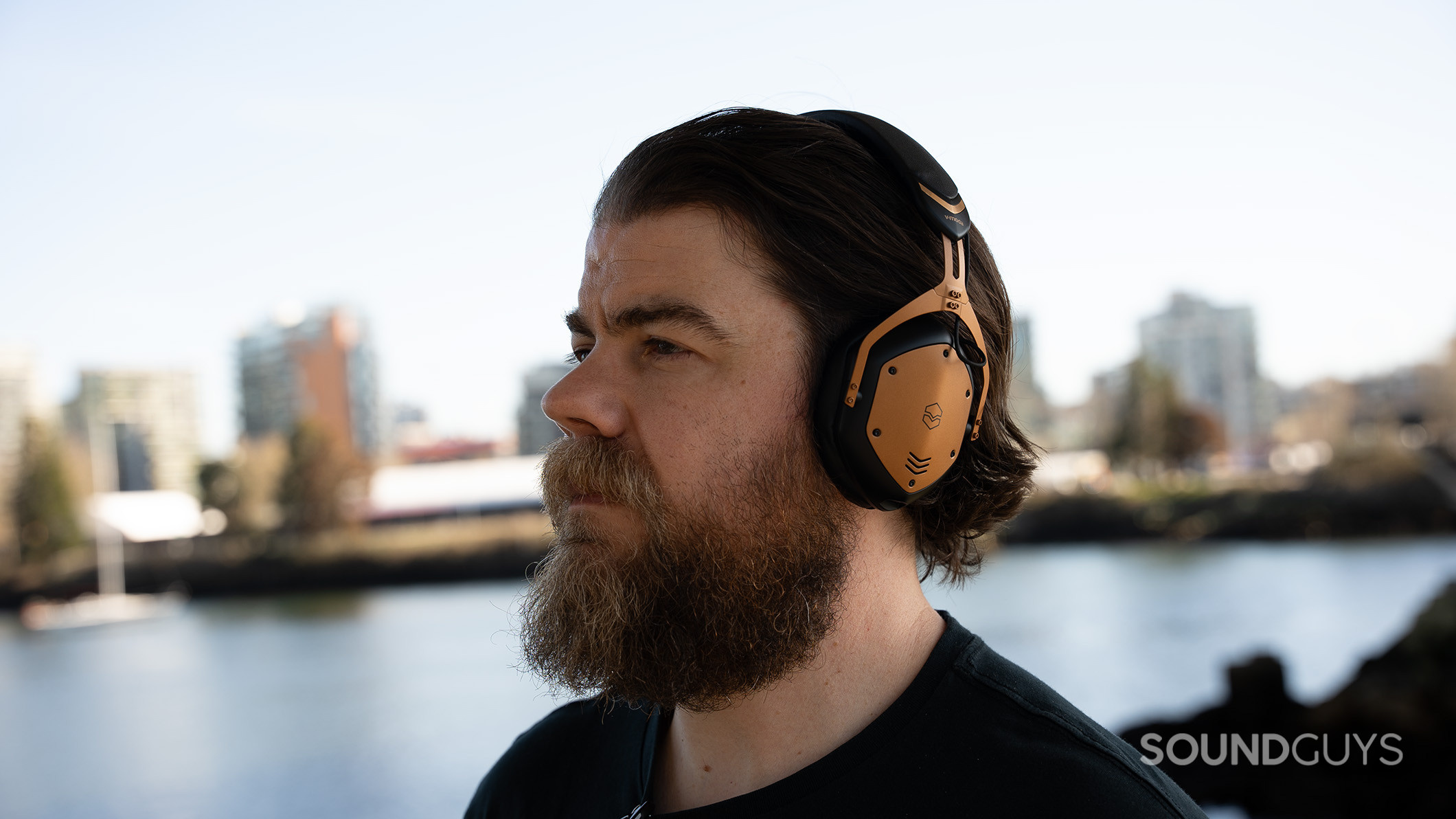 A man wearing the V-MODA Crossfade 3 Wireless headphones in front of water.