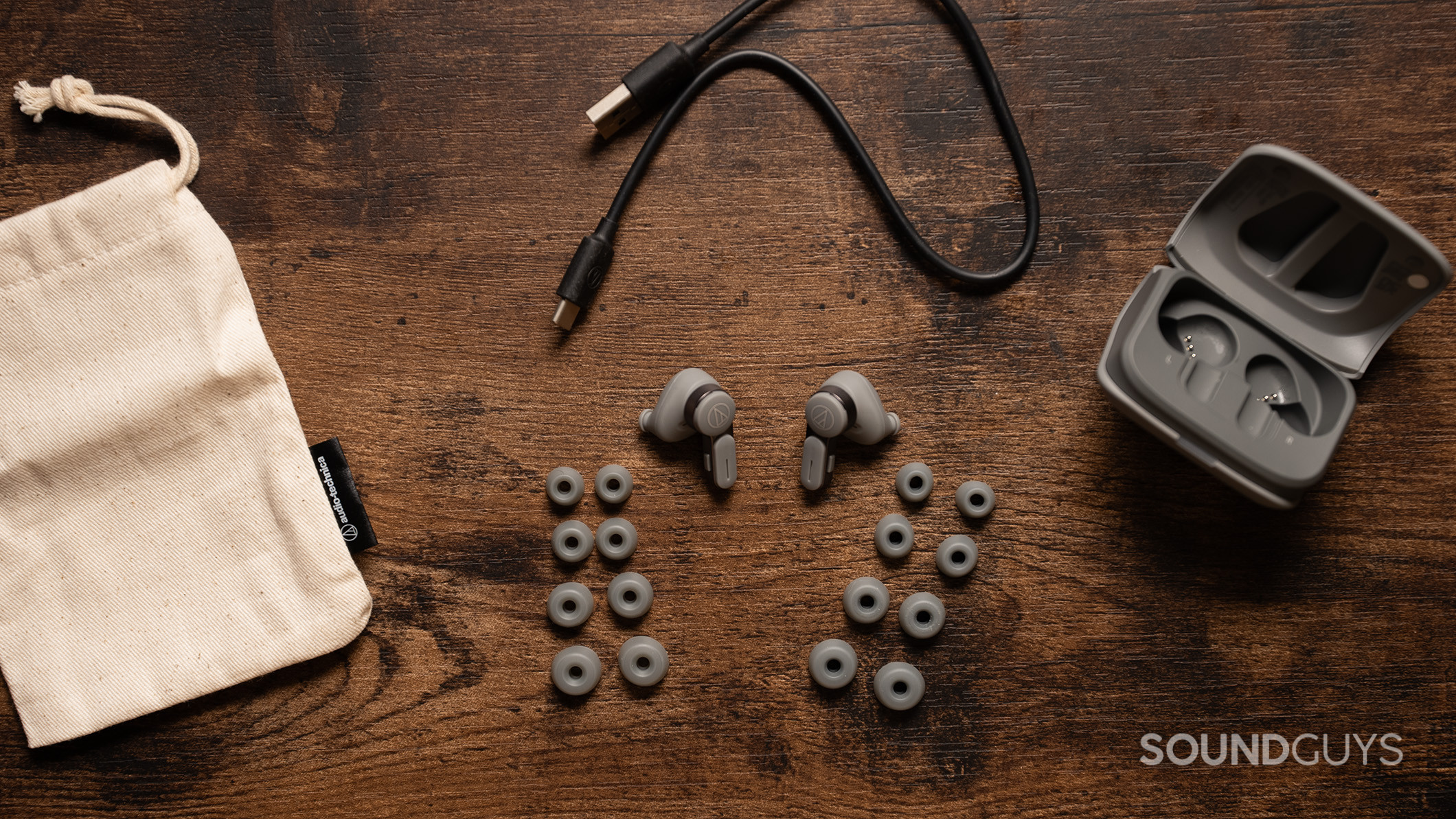 The Audio-Technica ATH-TWX7 earbuds alongside the included ear tips, cloth carrying case, and USB-C charging cable. 