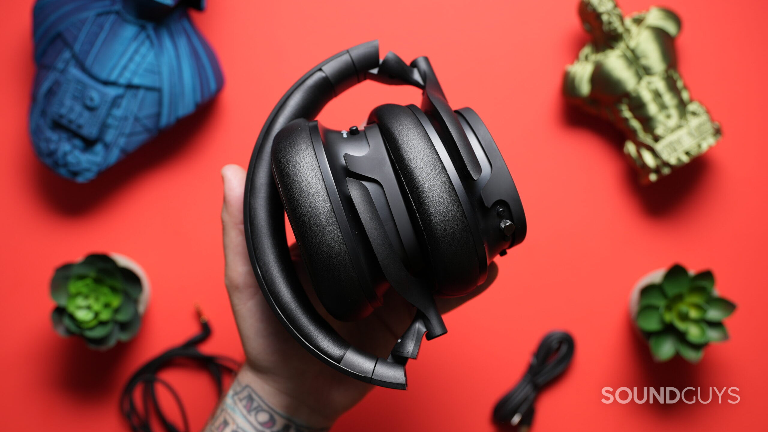 Top down photo of the Heavy H1H headphones folded up, held in a hand.