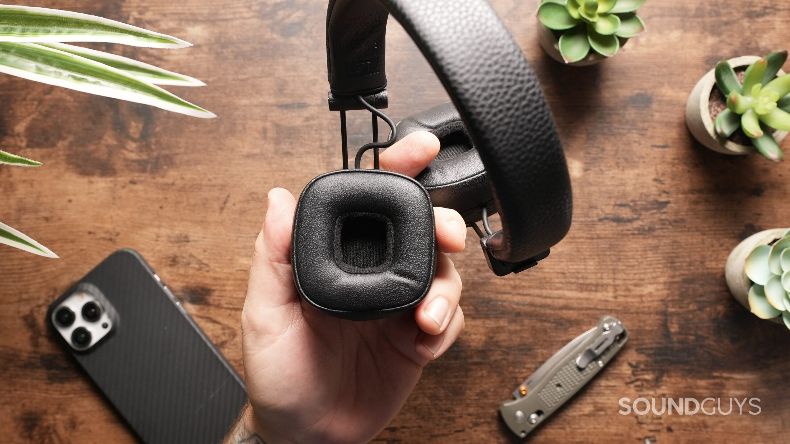 A hand holding the Marshall Major V headphones, showing the inside of the ear cup.