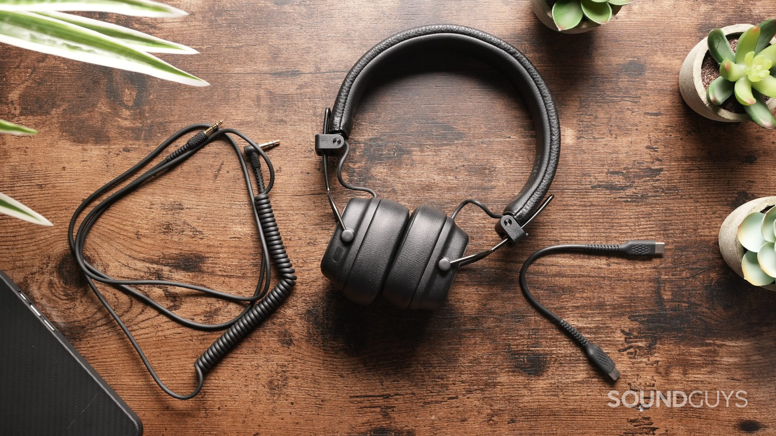 Marshall Major V headphones on a table with its 3.5mm and USB-C cables.