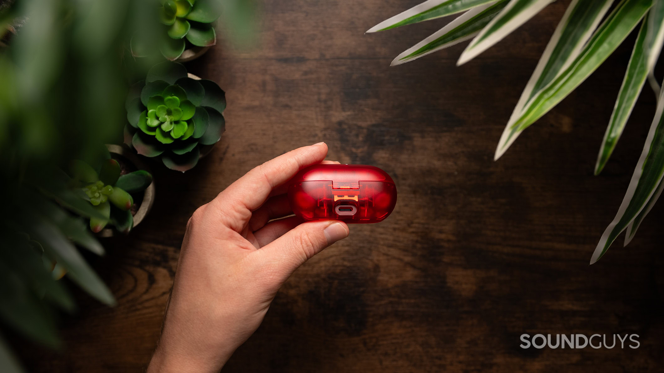 A hand holds the Beats Solo Buds showing the USB-C charging port.