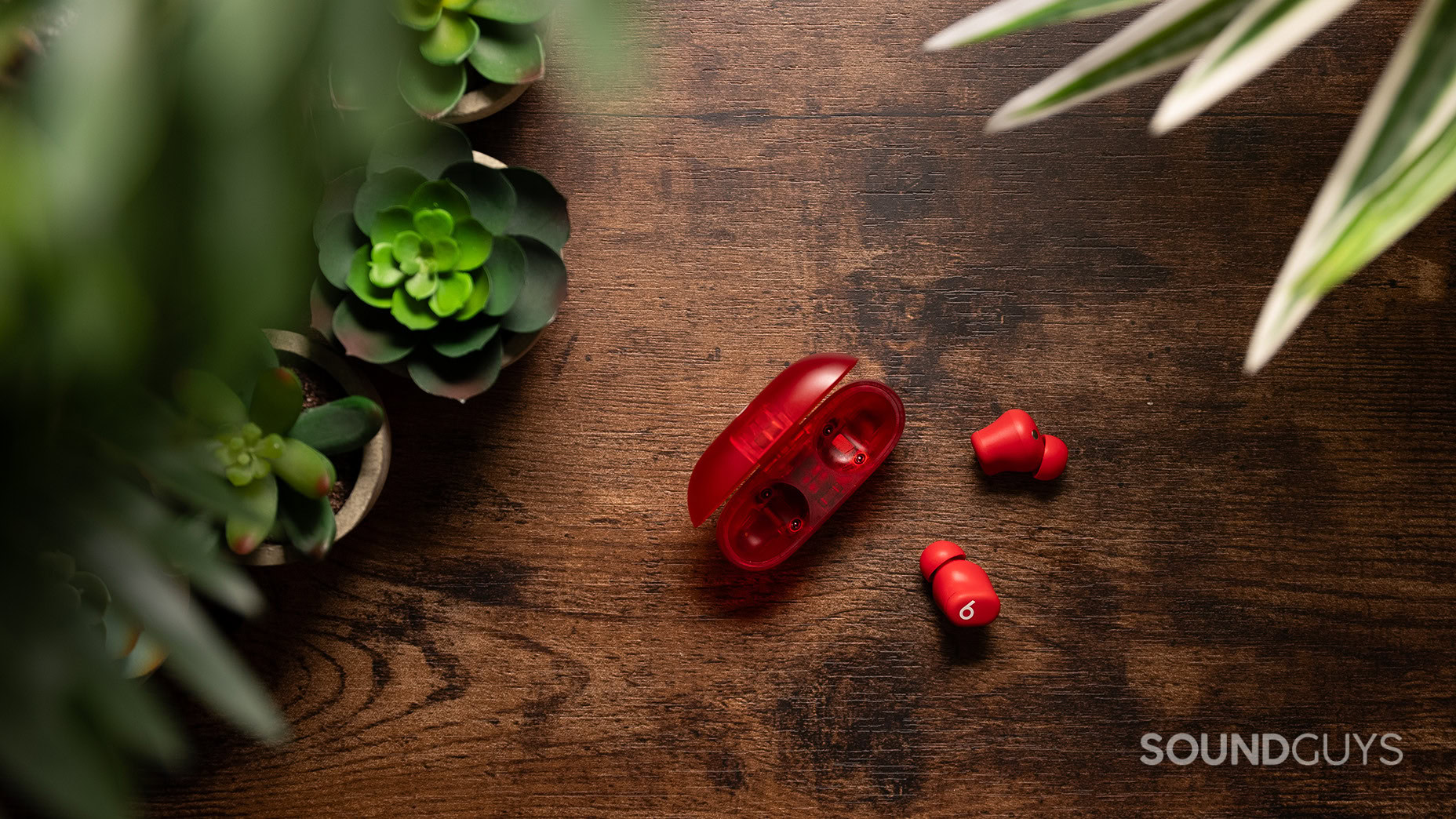 The Beats Solo Buds on a table with the earbuds next to the charging case. 