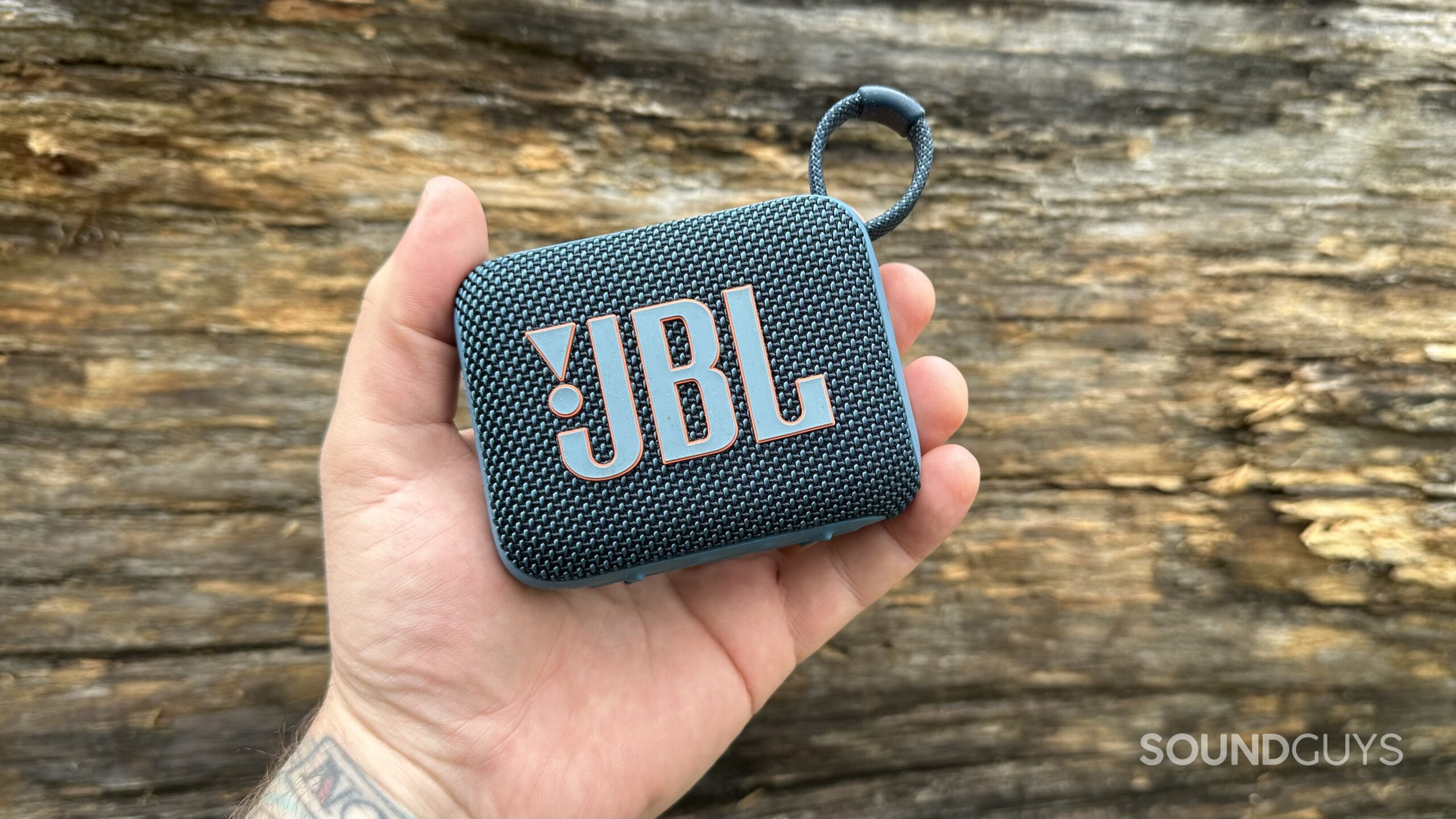 A JBL Go 4 in the palm of a hand.